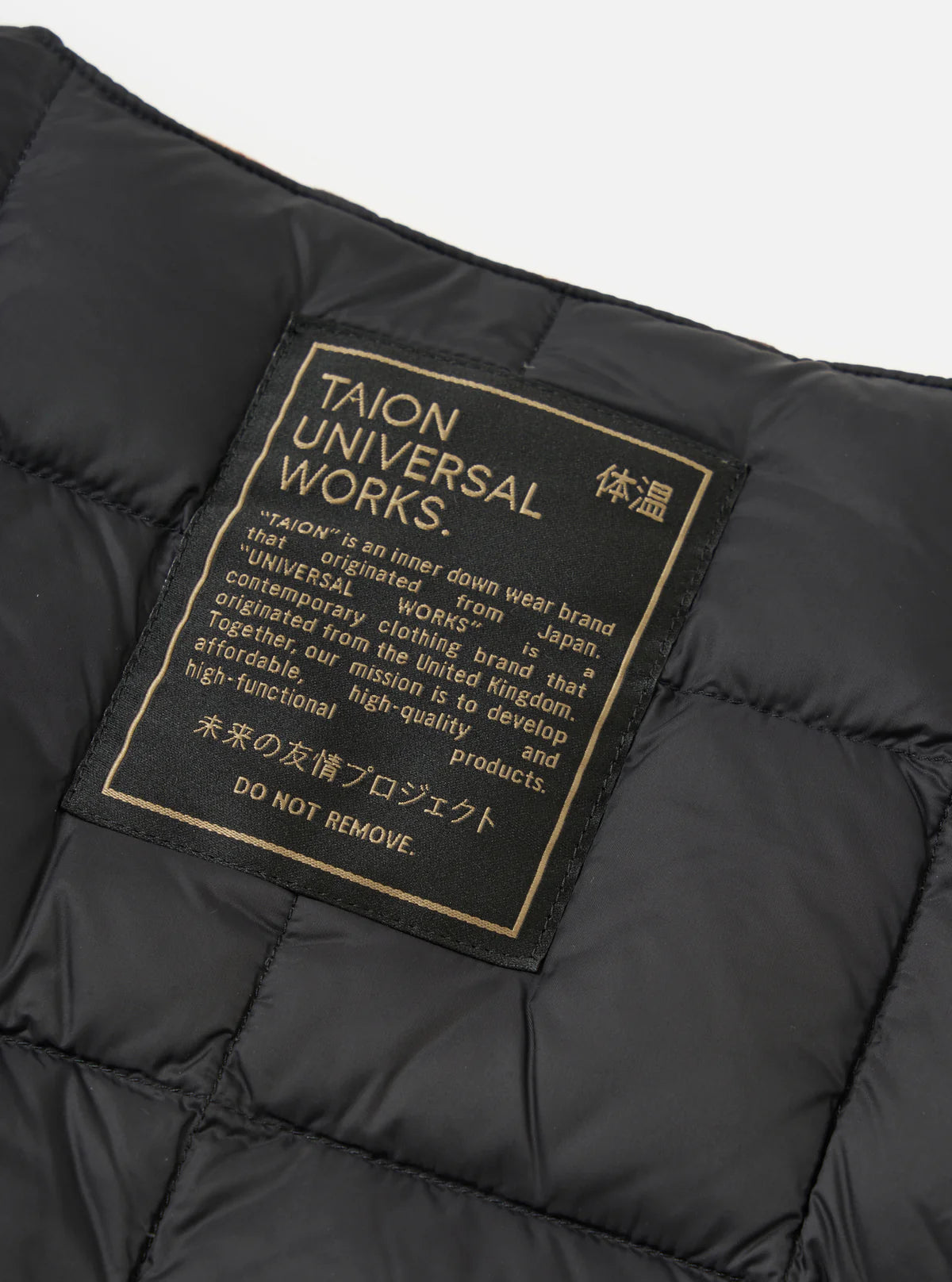 Black puffer jacket with 'TAION UNIVERSAL WORKS' label on a gray background
